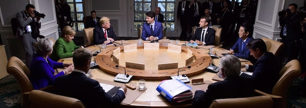Une session de travail au G7 avec (dans le sens d'un horloge) Justin Trudeau, Emmanuel Macron(France), Shinzo Abe(Japon), Guiseppe Conte(Italie), Jean-Claude Junker(Commission Européenne), Donald Tusk(Conseil Européen), Theresa May(Grande-Bretagne), Agela Merkel(Allemagne) et Donald Trump(États-Unis)