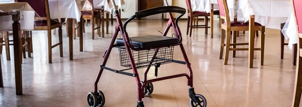 Une marchette abandonnée dans une salle à manger vide. 