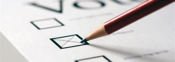 Un crayon trace une croix sur un bulletin de vote. 
