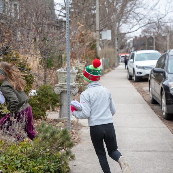 Des jeunes distribuent des lettres dans un quartier résidentiel à l'ouest du centre-ville de Toronto.