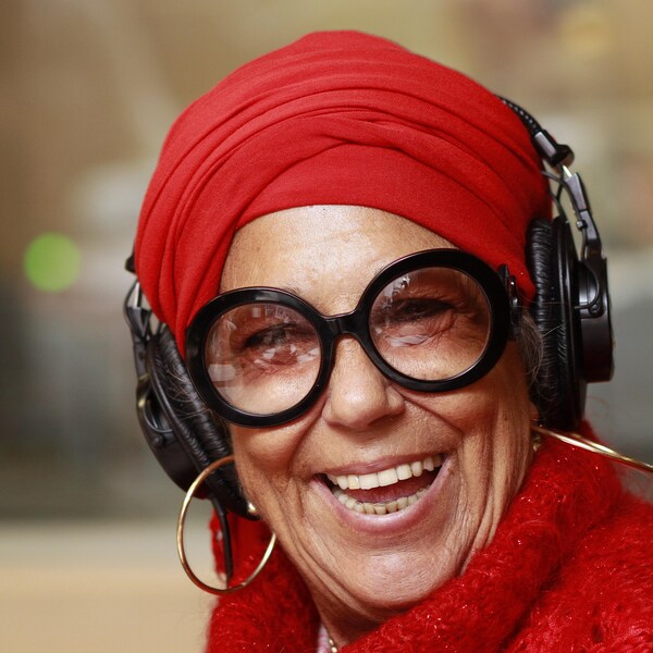 Francine Grimaldi, vêtue d'un pull de laine rouge et d'un turban rouge, rit aux éclats dans le studio 18 de Radio-Canada.