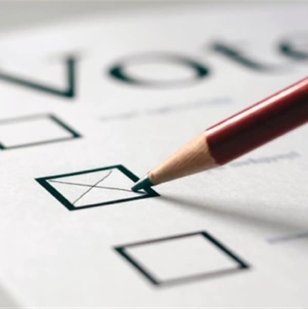 Un crayon trace une croix sur un bulletin de vote. 