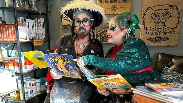 Deux drag queens regardent des livres pour enfants ensemble.