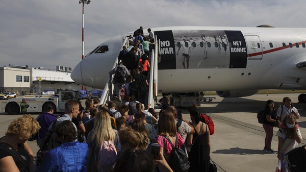 Des personnes montent à bord d'un avion.