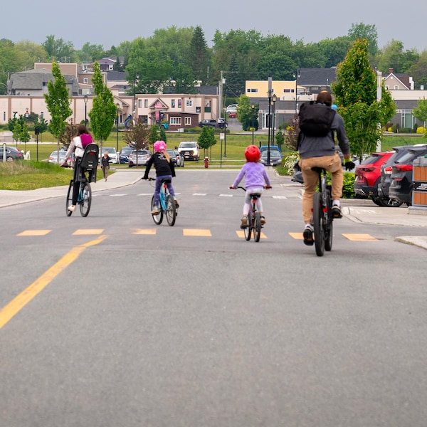 Une famille à vélo dans une rue de Lac-Mégantic.