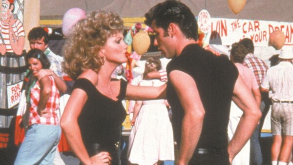Une jeune fille (Olivia Newton-John) et un jeune homme (John Travolta) habillés tout en noir dansent.