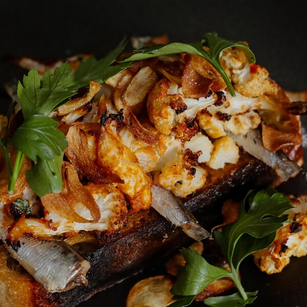 Une assiette de bruschetta au chou-fleur rôti et aux sardines.