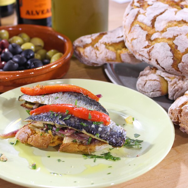 Filets de sardines grillés dans une assiette avec la compote d'oignons.