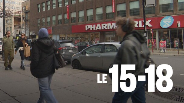 Des piétons marchent sur un trottoir.
