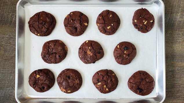 Une plaque de cuisson avec des biscuits au chocolat cuits.