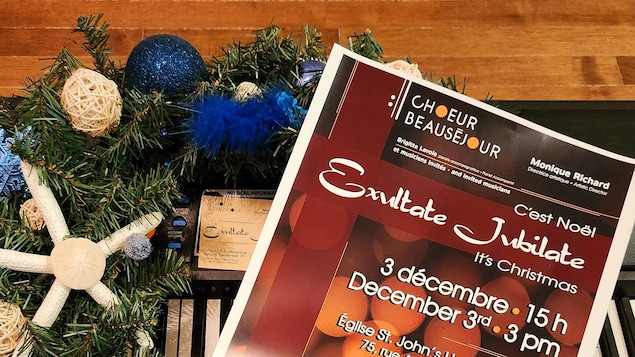 Une affiche déposée sur un piano où on peut lire les informations concernant un spectacle de Noël du Chœur Beauséjour.