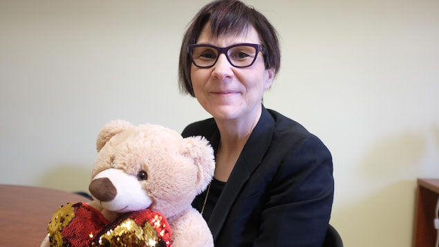 La professeure Cindy Blackstock pose avec un ourson, mascotte de sa cause, dans son bureau à l'Université McGill.