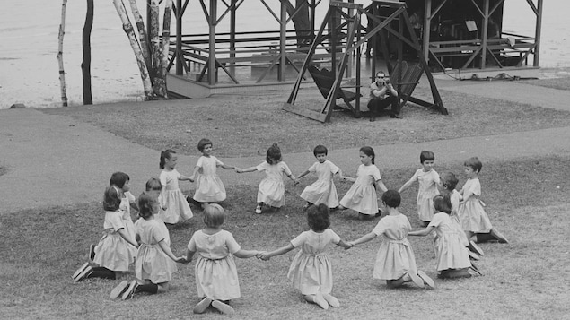 Des fillettes font la ronde sur le site d'un camp de vacances sur le bord de l'eau à Val-David, dans les Laurentides.