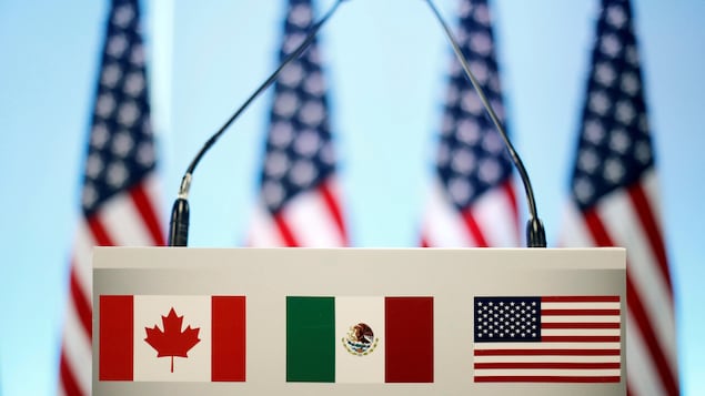 Les drapeaux du Canada, du Mexique et des États-Unis sont vus sur un lutrin avant une conférence de presse conjointe sur la clôture de la septième ronde de négociations de l'ALENA à Mexico.