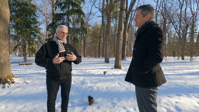 Bruno Savard et Gaston Déry parlent dans une forêt enneigé. Deux écureuils sont présents, dont un près de M. Déry.