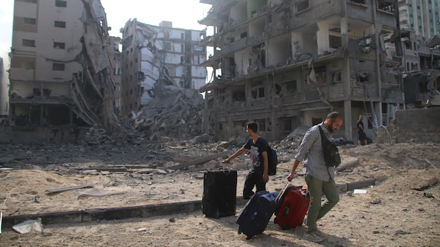 Des Palestiniens évacuent leurs maisons après des frappes aériennes israéliennes à Gaza.