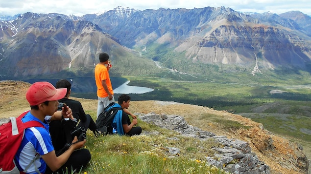 Des jeunes regardent au loin lors d'une randonnée en montagne.