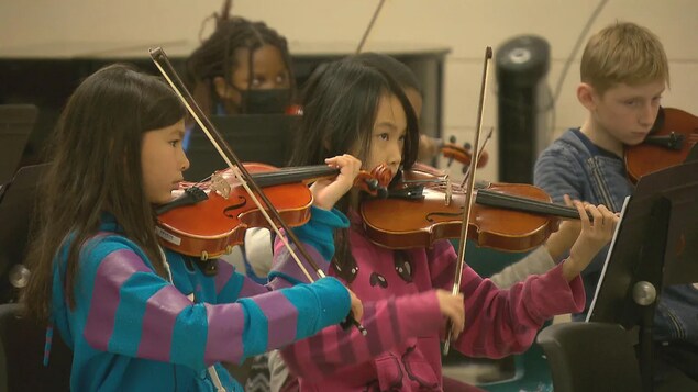 Des enfants jouent du violon.