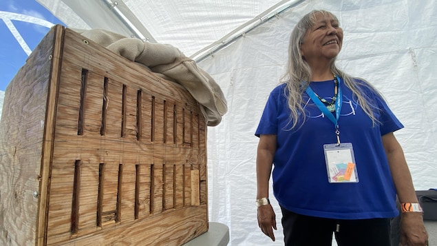 Joanne Williams se tient debout près d'une boîte en bois cintré.