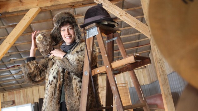 Liliane Pellerin grimpée dans un escabeau.