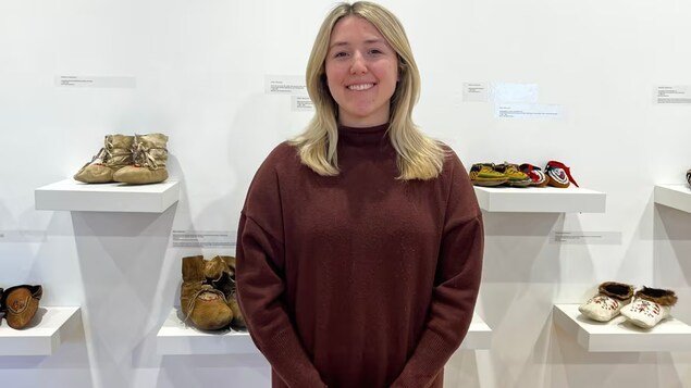 Margaret Firlotte devant des mocassins exposés.