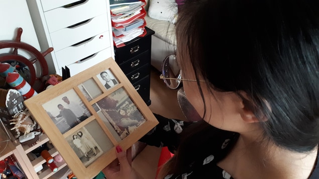 Une jeune fille regarde des photographies de sa famille