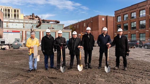 Des hommes, pelle à la main, sur le chantier.