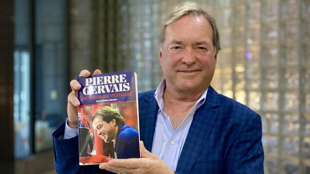 Pierre Gervais tient son livre intitulé Au cœur du vestiaire.