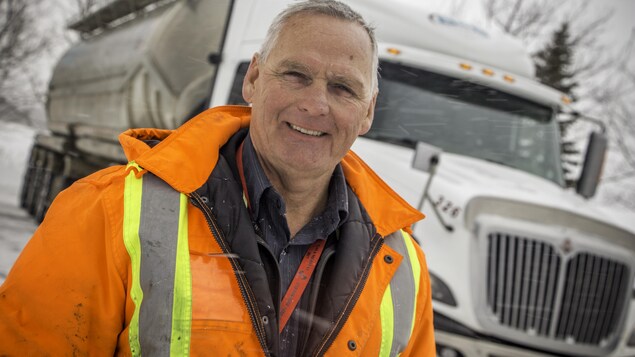 Richard Bilodeau devant un camion de transport. 