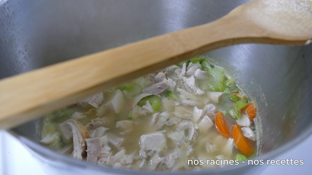 Une soupe au poulet, aux pommes de terre et aux légumes dans un chaudron. 