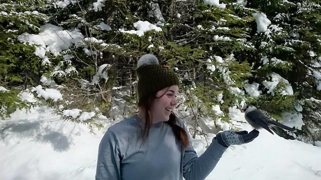 Tanya dans un paysage d'hiver, un oiseau perché sur sa main.