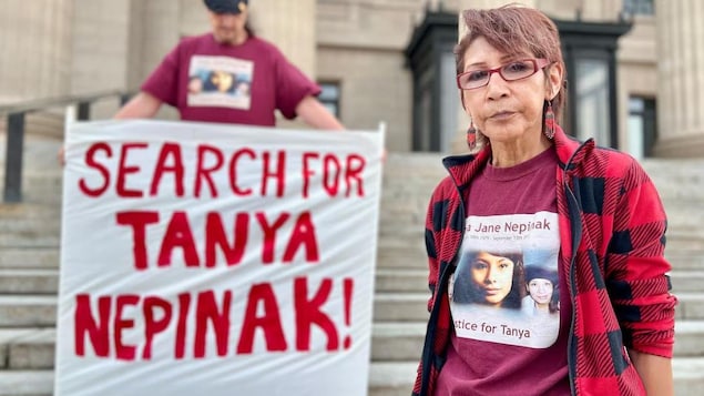 Des manifestants brandissent des pancartes réclamant la reprise des recherches pour Tanya Nepinak devant l’Assemblée législative du Manitoba.
