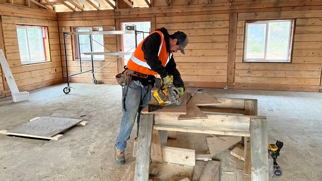 Josh Charlie avec des outils travaillant sur un morceau de bois. 