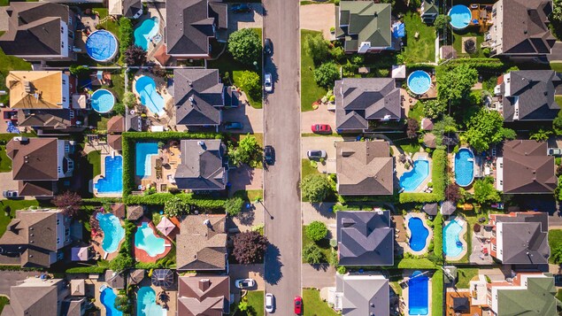 Vue aérienne de piscines et de maisons dans un quartier résidentiel typique de banlieue.