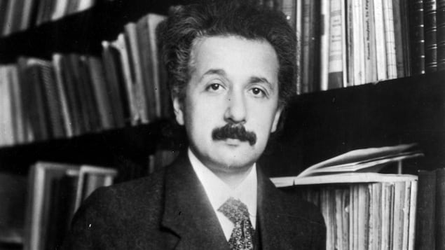 Albert Einstein devant une bibliothèque.