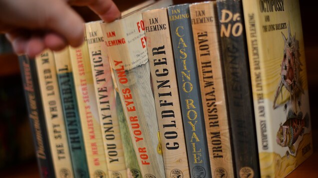 Gros plan sur une collection complète d'exemplaires de la première édition des livres James Bond d'Ian Fleming sur une étagère. 