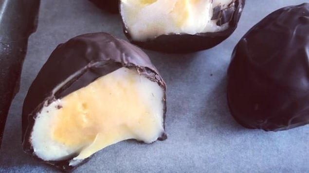 Des œufs de Pâques en chocolat sont disposés sur un plan de travail.