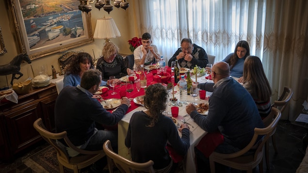 Neuf personnes mangent à une table.