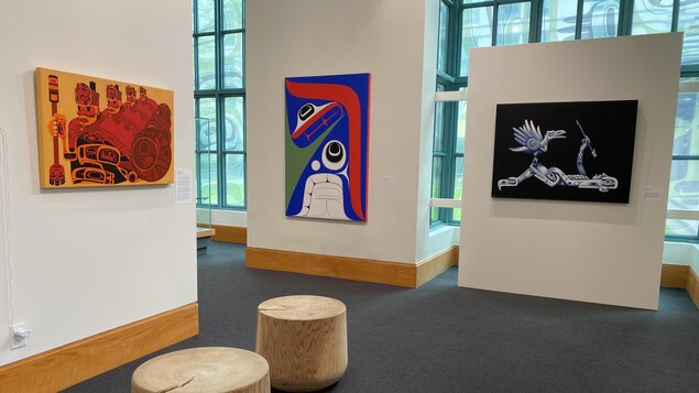 Trois tableaux d'artistes autochtones accrochés dans un musée.