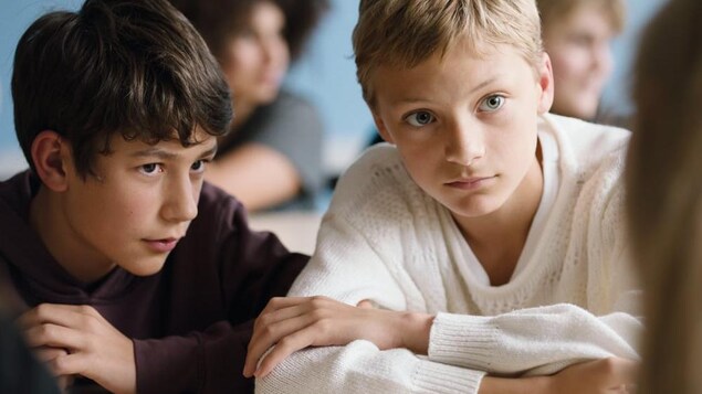 Deux jeunes garçons assis côte à côte.