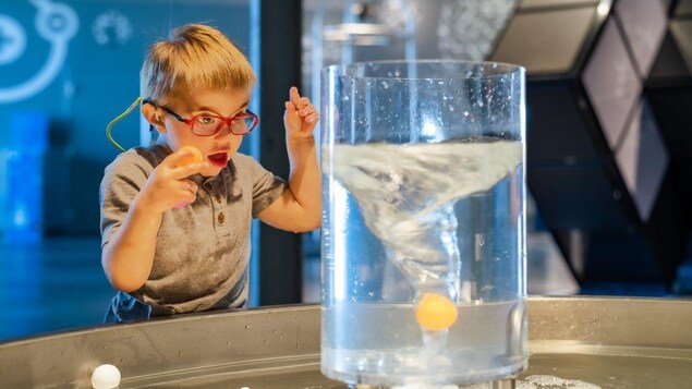 Un enfant avec des besoins spéciaux regarde une expérience scientifique avec enthousiasme