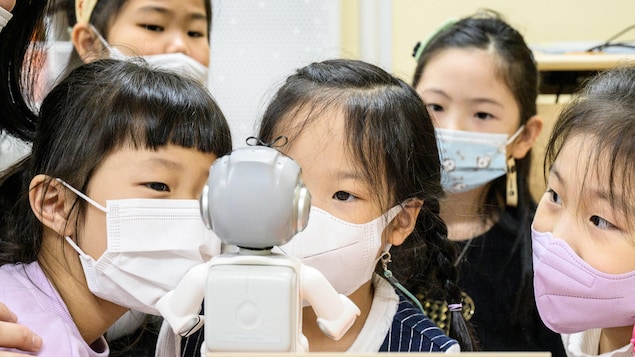Cinq jeunes enfants sud-koréens interagissent avec un robot Alpha Mini