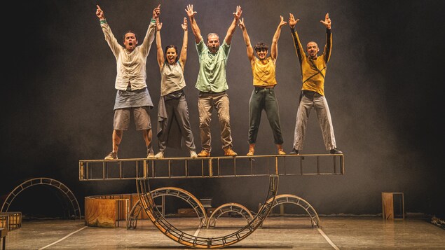 Photo d'un spectacle de cirque : 5 artistes lèvent les bras au ciel