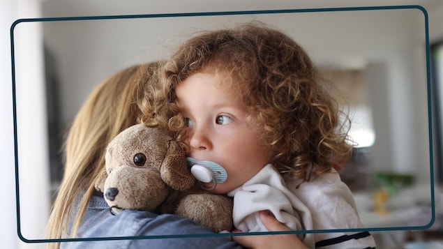 Une maman rassure sa petite fille en lui faisant un câlin.