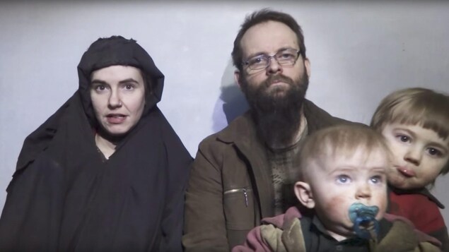 Capture d'écran de Caitlan Coleman qui s'adresse à la caméra pendant que son époux Joshua Boyle tient deux de leurs enfants dans ses bras.