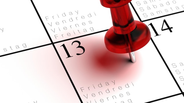 Un calendrier avec une punaise piquée dans la case du vendredi 13