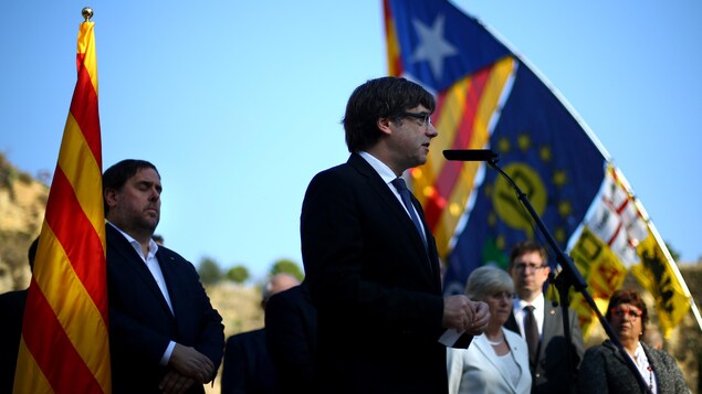 Il est au micro devant son vice-président, entourés tous les deux de drapeaux