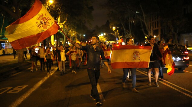 Des manifestants, opposés à l’indépendance de la Catalogne, brandissent des drapeaux de l’Espagne dans Barcelone, le mercredi 4 octobre 2017.