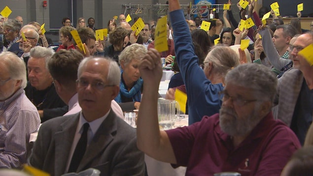 Des membres de la SFM votent à main levée lors de l'assemblée générale annuelle de l'organisme. Au premier plan : Philippe Mailhot (à g.) et Léo Robert
