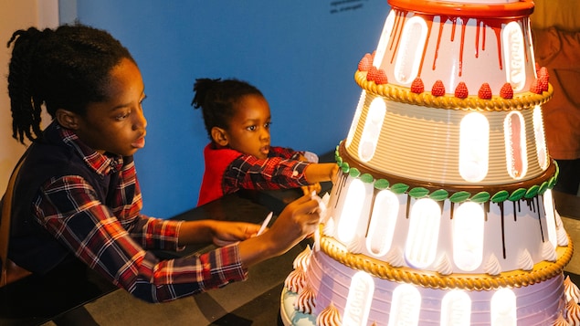 Deux enfants s'amusant dans l'exposition Banquet au Centre des sciences de Montréal.